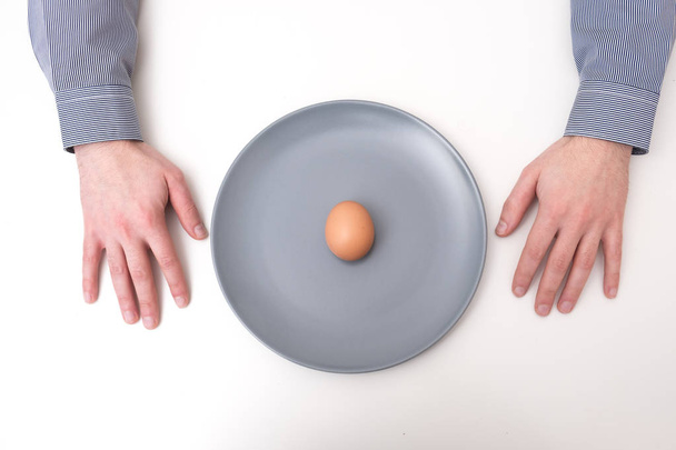 Hands near uncooked egg in a dish - Foto, Imagem
