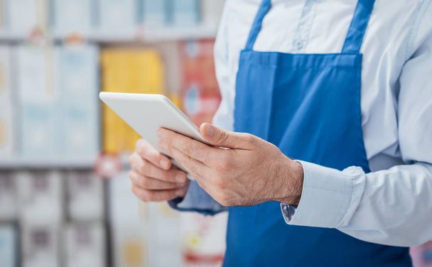 Supermarket clerk using apps on tablet - Photo, Image