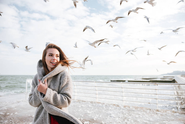 Smiling woman standing on pier in winter - Φωτογραφία, εικόνα