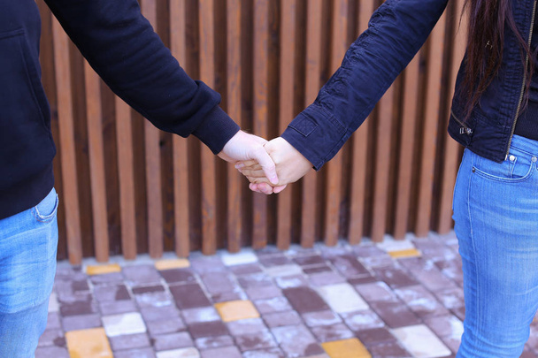 Las personas que aman firmemente se toman de la mano y se superan mutuamente, de pie
 - Foto, imagen
