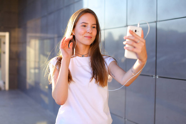 Szép fiatal női lány diák gazdaság telefon, mosolyogva, hullám - Fotó, kép