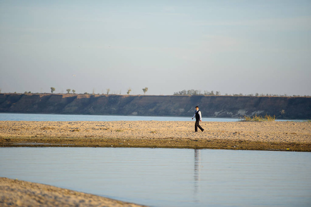 stylish man walking on the sand - Фото, изображение