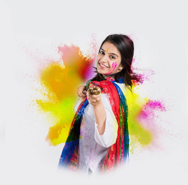 Beautiful Indian young woman celebrating Holi festival, isolated over white background with copy space - Photo, Image