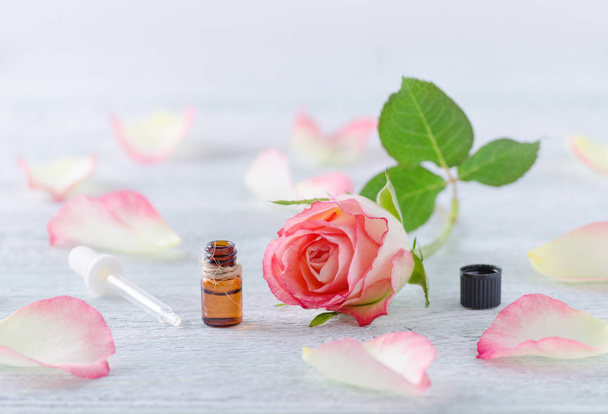 jeden ml láhev s esenciální olej, přírodní růže květ a pipetou na dřevěné vintage - Fotografie, Obrázek