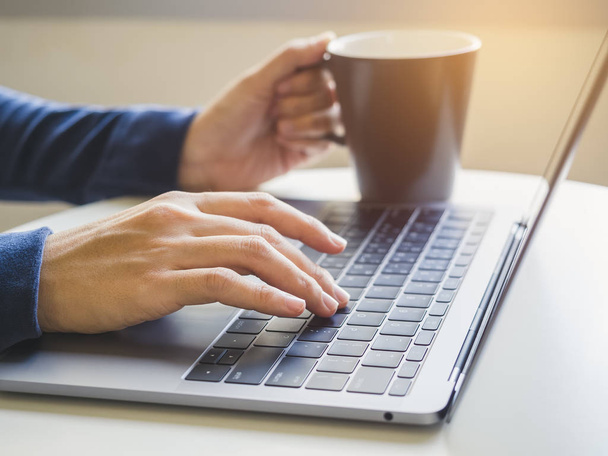 Femme main type sur clavier d'ordinateur portable avec tasse de café
  - Photo, image