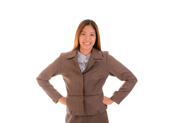 Happy businesswoman in brown suit is smiling and arms akimbo on white background. - Photo, Image