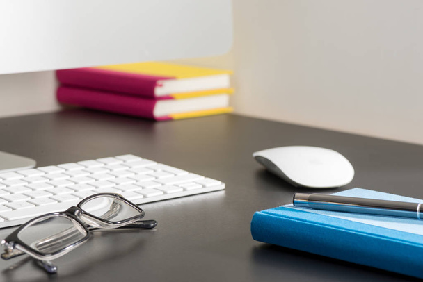Ноутбук, ручка и очки Наряду с компьютером на рабочем столе
 - Фото, изображение