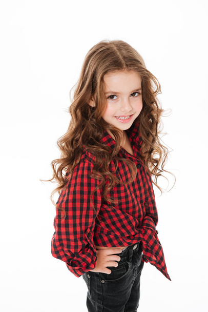 Happy cute little girl in plaid shirt standing and posing - Foto, Imagen