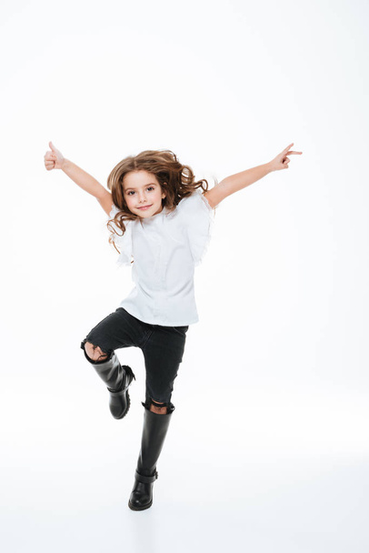 Full length of happy little girl jumping in the air - Fotó, kép