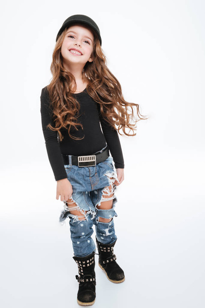 Cheeful curly little girl in hat and torn jeans - Photo, Image