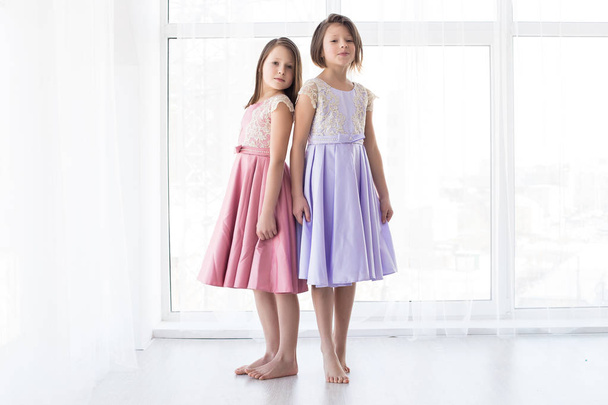 Dos hermosas hermanas con vestidos de moda. Son muy lindos y hermosos.
 - Foto, Imagen