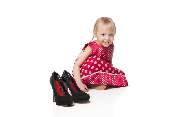 Smiling little girl with big shoes - Valokuva, kuva