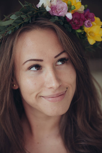 junges Frauenporträt mit Frühlingsblumenkranz, Frühjahrsmodekonzept - Foto, Bild