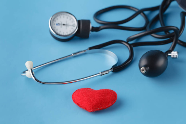 Srdce zdravotnické koncepce, thonometer a hračka srdce na modré pozadí - Fotografie, Obrázek