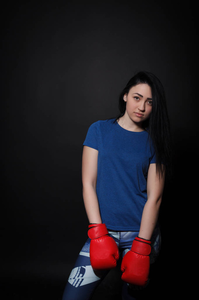 Woman in red boxing gloves. Sport woman on a black background - Valokuva, kuva