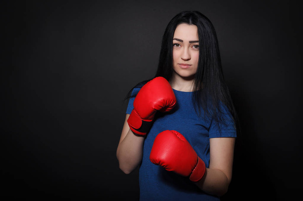 Kobieta w czerwonym rękawice bokserskie. Kobieta Sport na czarnym tle - Zdjęcie, obraz