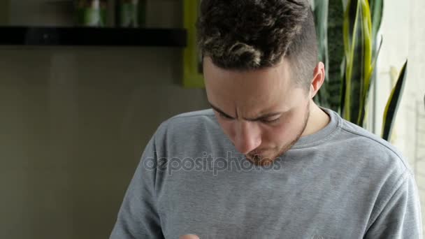 Wysyłanie SMS-ów człowiek na smartphone przez okno w domu - Materiał filmowy, wideo