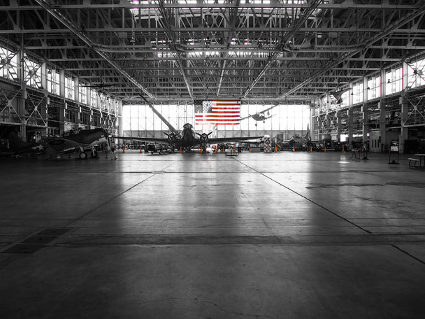 Foto en blanco y negro del hangar de aviones con bandera americana de colores
 - Foto, imagen