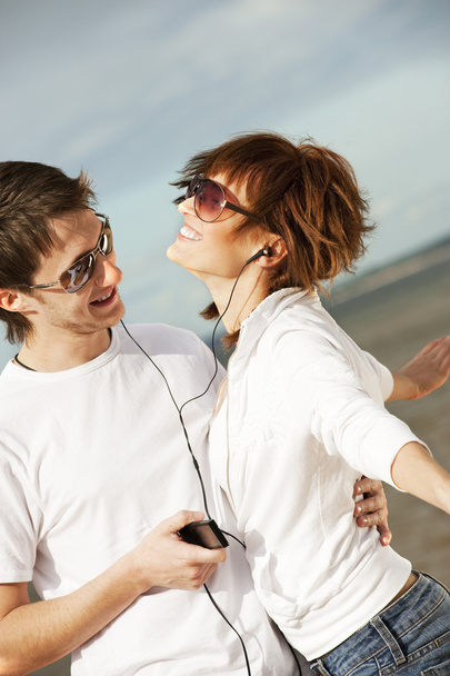 Happy young couple listening to music together - Photo, Image