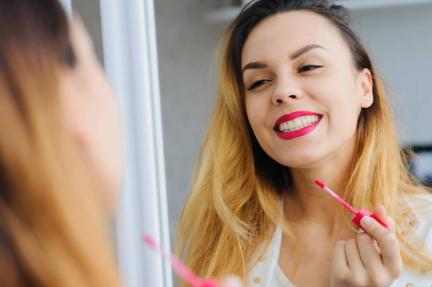 young woman applying lipstick  - Foto, immagini