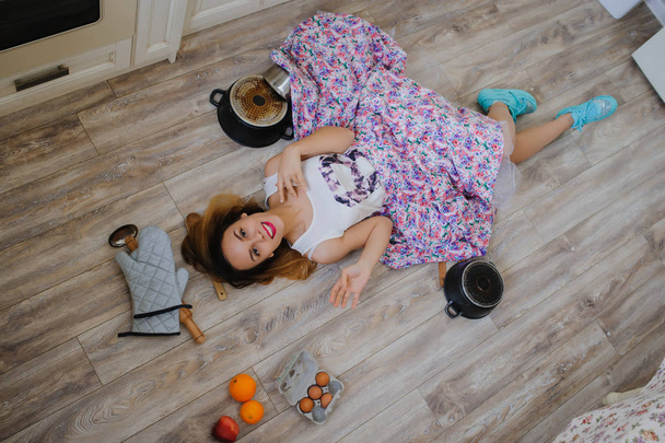 νεαρή γυναίκα ξαπλωμένη στο πάτωμα σε μια vintage κουζίνα - Φωτογραφία, εικόνα