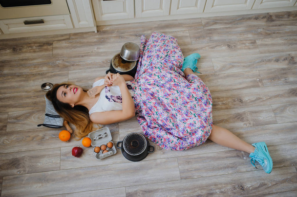 νεαρή γυναίκα ξαπλωμένη στο πάτωμα σε μια vintage κουζίνα - Φωτογραφία, εικόνα
