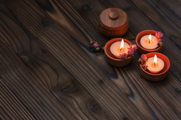 Pêcher les petites bougies dans des tasses en bois avec des fleurs séchées
 - Photo, image