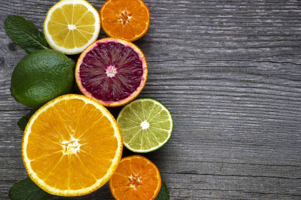 Citron, orange rouge, orange, pamplemousse, citron vert sur une vieille table en bois
. - Photo, image