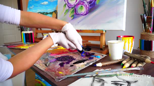 Ammunta lähikuva tyttö kädet taiteilija puristaa maali putkesta paletti että olisi toimintaa maalaus
. - Materiaali, video
