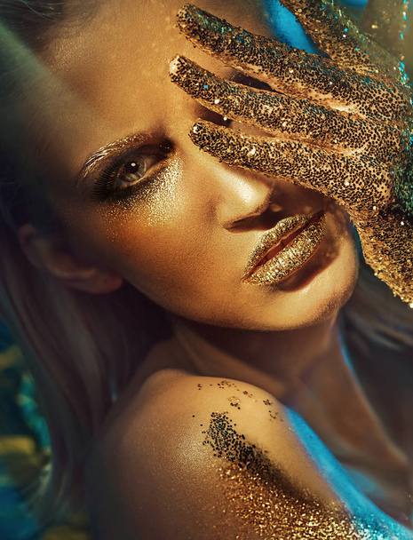 Beautiful woman with glittering golden hands and lips - Fotoğraf, Görsel