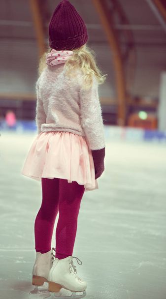Patines de niña bonita con gorra roja, guantes calientes y suéter
 - Foto, Imagen