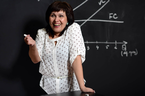 Érett nő tanár magyarázza a leckét a gazdaság. - Fotó, kép