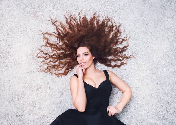 Woman with beauty long brown hair lying on the floor - Valokuva, kuva