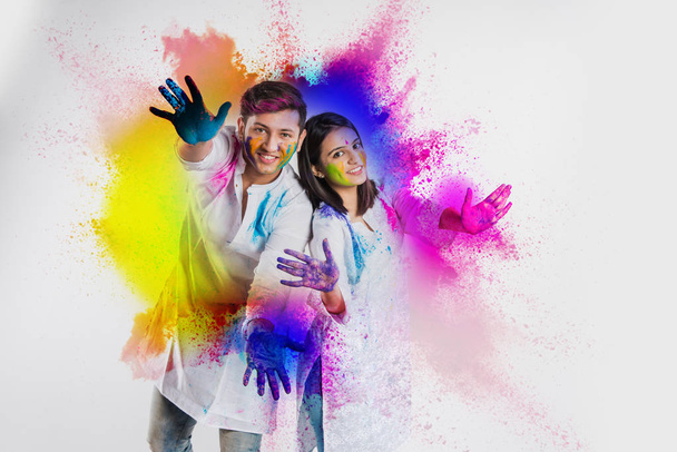 young indian couple in traditional wear with faces painted  celebrating Holi, isolated over white background - Photo, Image