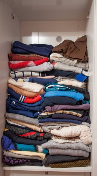 белые шкафы со сложенными свитерами
 - Фото, изображение