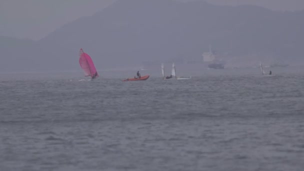 Windsurfer üben im Ozean, während sich das Schiff im Hintergrund bewegt - Filmmaterial, Video