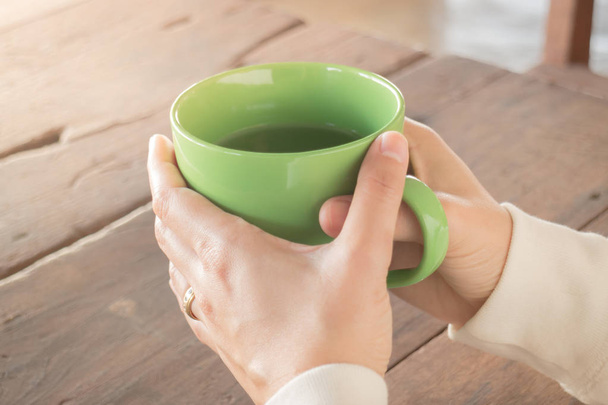 Žena ruku na horký zelený čaj pít - Fotografie, Obrázek