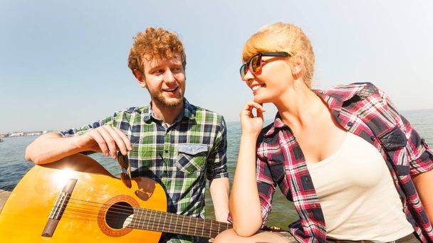 Young man hipster playing guitar for woman. - Foto, Imagem