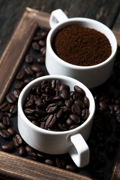 ground coffee and coffee beans in cups, vertical closeup - Foto, Imagen