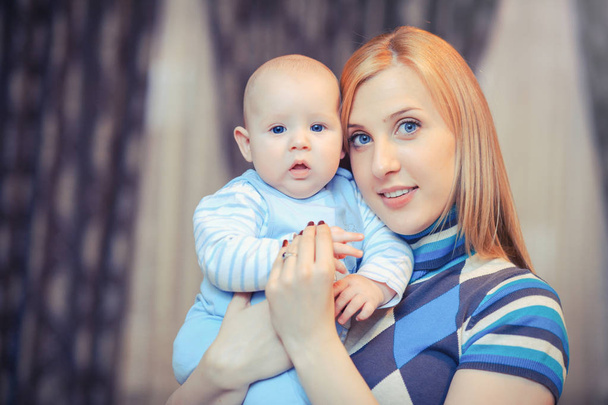 beautiful blue-eyed mother with baby - Photo, Image
