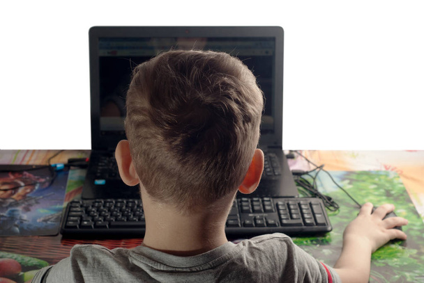 маленький мальчик смотрит видео на ноутбуке на белом фоне
 - Фото, изображение