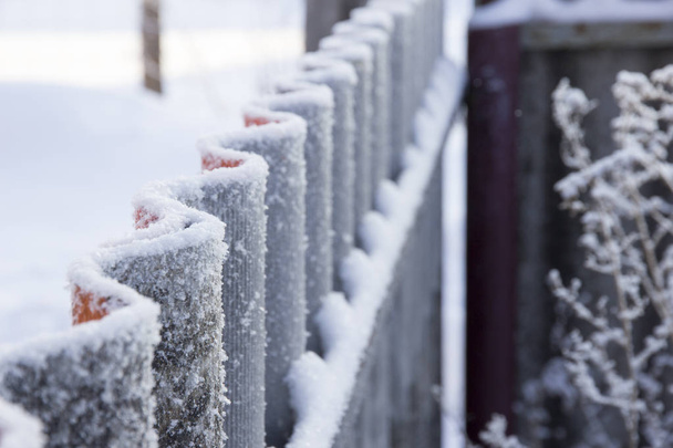 Wavy fence covered with frost in perspective - Photo, Image