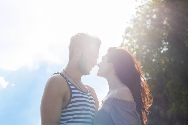 Paar glücklich lächelnd blauer Himmel Sonnenschein, schöne junge Menschen verliebt, Mann und Frau umarmen sich - Foto, Bild