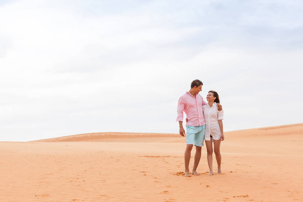 Jonge Man vrouw In woestijn Beautiful Couple Aziatisch meisje en Guy Embrace zandduin - Foto, afbeelding