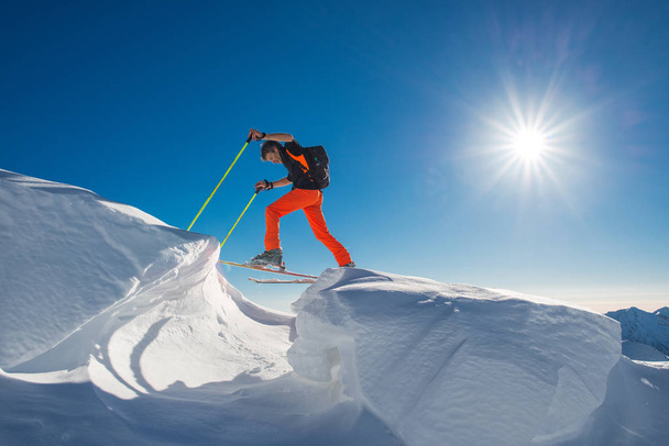 ein Mann Alpinskifahrer klettert auf Skiern und Robbenfellen in so viel Schnee  - Foto, Bild