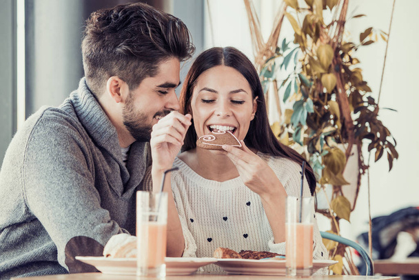 Happy young couple having breakfast in cafe - Photo, Image