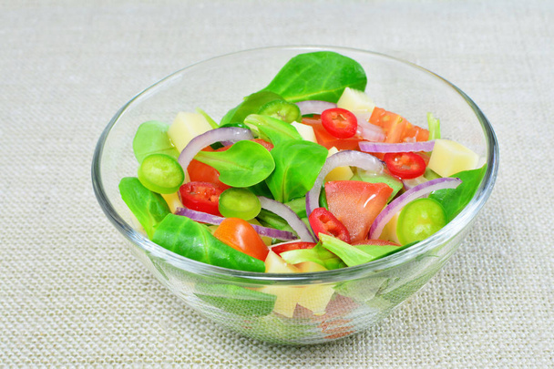 Salada de legumes frescos em tigela de vidro na mesa
 - Foto, Imagem