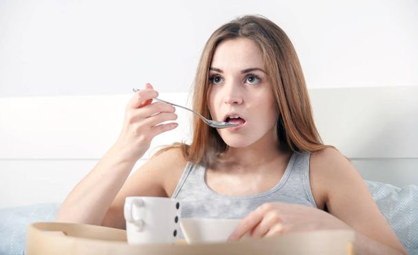 Morning at home, woman in bed eating breakfast - Фото, зображення