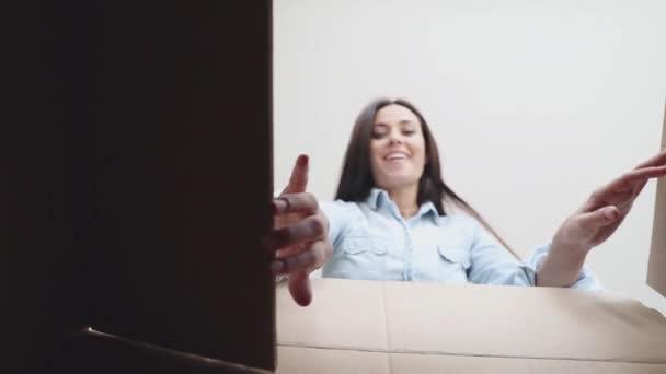 Uśmiechnięta kobieta, biorąc coś z pudełka - Materiał filmowy, wideo