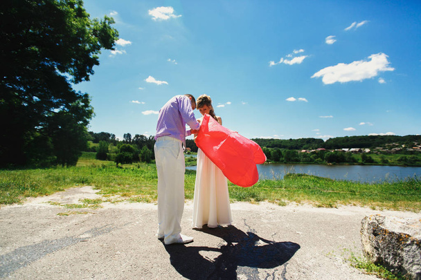 Newlyweds holding red lantern - Φωτογραφία, εικόνα